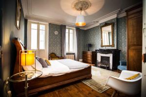 a bedroom with a large bed and a fireplace at Carcassonne Townhouse in Carcassonne