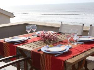 uma mesa com uma toalha de mesa vermelha e copos de vinho em Beach House, 50 meters from the sea em São Pedro de Moel