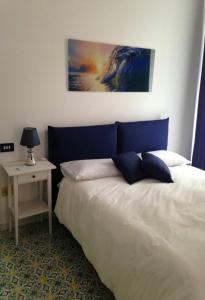 a bedroom with a bed with a blue headboard and a table at Il sorriso in Salerno