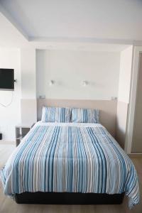 a bed with a striped comforter in a bedroom at Modern & Stylish Loft with Breathtaking Views FREE WIFI - Close to the sea in Málaga
