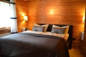 sypialnia z łóżkiem w drewnianej ścianie w obiekcie Family 9 w mieście Ulmen