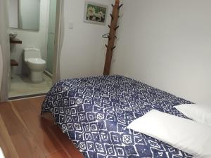 a bedroom with a bed with a blue and white comforter at Elizabetha Hostal in Salento +37 photos