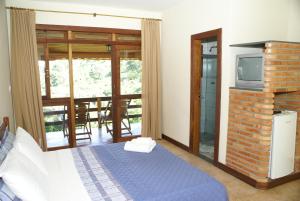 ein Schlafzimmer mit einem Bett und einem TV in einem Zimmer in der Unterkunft Pousada Fazenda do Engenho in Serra do Cipo