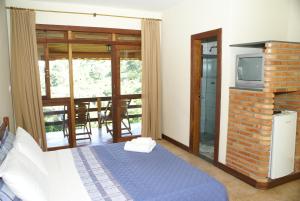 a bedroom with a bed and a tv in a room at Pousada Fazenda do Engenho in Serra do Cipo