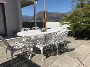 a white table and chairs on a patio with a view at Studio pool room in Hout Bay