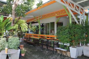 an outdoor seating area of a restaurant with tables and chairs at Thanyachatra Boutique in Phetchaburi