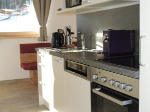 a kitchen with a sink and a stove top oven at Buttererhof-Apartments in Fulpmes