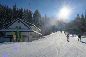 a group of people skiing down a ski slope at Apartmany Biela Put - Veverica in Demanovska Dolina