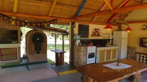 Una cocina al aire libre con una mesa y un horno. en Cabañas Entre Verde, en Los Hornillos