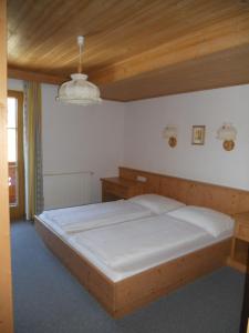Bett in einem Schlafzimmer mit Holzdecke in der Unterkunft Honsnhof in Tux