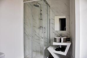 bagno con doccia in vetro e lavandino di The Hygge Lisbon Suites - Estrela a Lisbona