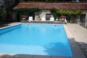 a large blue swimming pool in front of a house at Chateau de Fayolle in Ribérac