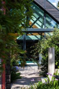 a glass building with a courtyard with plants at La Mare aux Oiseaux, The Originals Collection (Relais du Silence) in Saint-Joachim