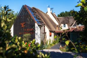 une vieille maison avec un panneau sur son côté dans l'établissement La Mare aux Oiseaux, The Originals Collection (Relais du Silence), à Saint-Joachim