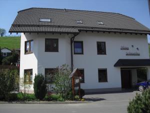 a white house with a black roof at Haus Schnurbus in Olsberg