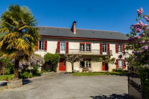 ein Haus mit roten Türen und einer Palme in der Unterkunft La Maison de L'Ousse in Livron