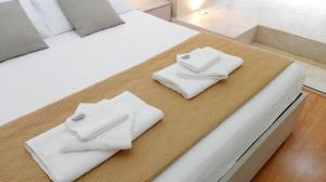two white towels are sitting on a bed at Casa Corso Umberto I, historic Main Street in Syracuse