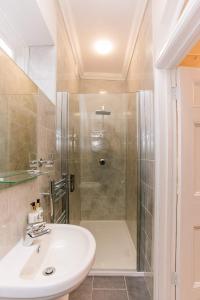 a bathroom with a shower and a white sink at The Old Rectory in Deal