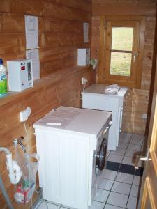 a kitchen with white appliances in a wooden cabin at Blockhaus Hedwig in Stamsried