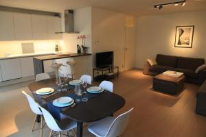 uma cozinha e uma sala de estar com mesa e cadeiras em NEW Design apartment in Brussels em Bruxelas