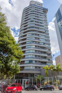 un edificio alto con coches estacionados frente a él en Be Paulista's Studios, en São Paulo