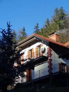 a white building with a balcony and a tree at Turistična kmetija Weiss in Miklavž pri Taboru