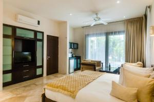a bedroom with a large bed and a television at Mak Nuk Village - Clothing Optional in Tulum