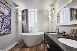 baño con 2 lavabos y bañera grande en Aparthotel Best Views en Cracovia