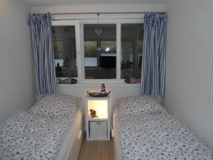 a bedroom with two twin beds and a window at Ferienwohnung Likedeeler in Wyk auf Föhr