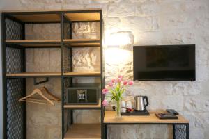 a book shelf with a tv and a table at City Port Hotel in Haifa
