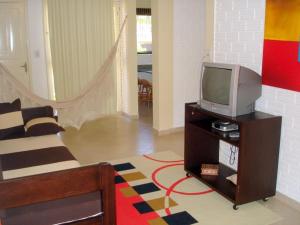a living room with a tv on a table at Pousada Cheiro De Mar in Imbituba
