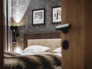 a bedroom with a bed with three pictures on the wall at Valentin Design Apartments in Sölden