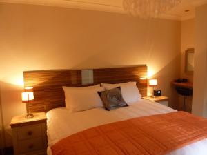 a bedroom with a large bed with a wooden headboard at Hewlett Apartments in Cheltenham