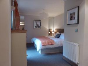 a bedroom with a bed and a chandelier at Hewlett Apartments in Cheltenham