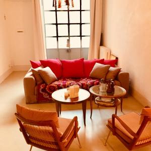 un soggiorno con divano rosso e 2 tavoli di 108 eclectic loft near corso Como milan a Milano