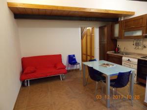 フィレンツェにあるIl gatto con gli stivali suite - locazione turisticaの赤いソファとテーブル付きのキッチン