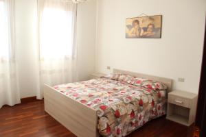 een slaapkamer met een bed met een dekbed en een raam bij Boccaor in Paderno del Grappa