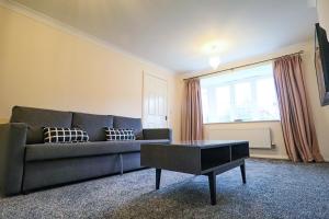 uma sala de estar com um sofá e uma mesa de centro em Royal Oak Home em Wythenshawe