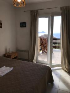 sypialnia z łóżkiem i przesuwnymi szklanymi drzwiami w obiekcie Villa Romarin w mieście Partinello