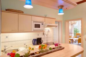 a kitchen with a counter with flowers on it at Pension Villa Edelweiß in Ostseebad Sellin