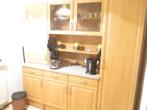a kitchen with wooden cabinets and a coffee maker at Ferienwohnung Schlothauer 1 in Ruhla