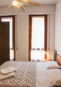 アレンツァーノにあるLocanda Vittoriaのベッドルーム1室(ベッド2台、シーリングファン付)