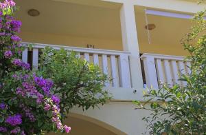 a house with a staircase with purple flowers at Apartments Šiljug in Cavtat