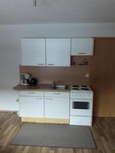 a kitchen with white cabinets and a stove at Ferienwohnung Wolf in Trins
