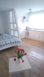 a room with a bed and a table with flowers on it at Apartment Seerose in Remseck am Neckar