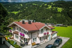 una casa con dos coches estacionados frente a ella en Appartement Kuen, en Zell am Ziller