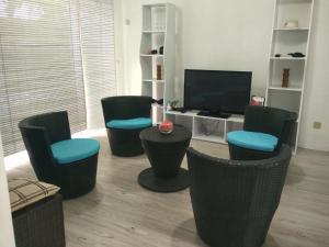 a living room with four chairs and a television at A1 Dittany of Crête in Grand-Baie