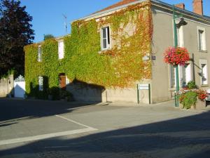 a building covered in ivy on the side of a street at Lalobema in Machecoul