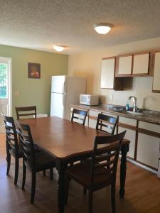 eine Küche mit einem Holztisch und Stühlen sowie einem Kühlschrank in der Unterkunft The Villas on Lake George in Diamond Point