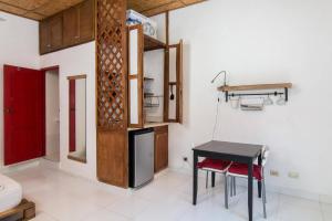 a kitchen with a black table and a red door at La Puerta Roja Guest House in Santo Domingo